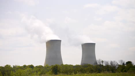 nuclear power plant on a warm cloudy day with steam rising - establishing shot with some movement