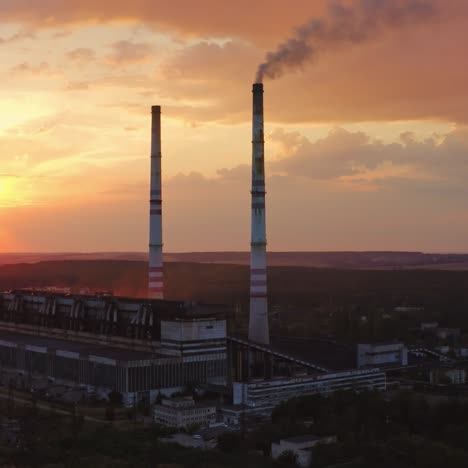 chemical plant in nature. dirty smoke goes from factory at sunset. industrial pipe with harmful emissions pollute the environment. aerial view.