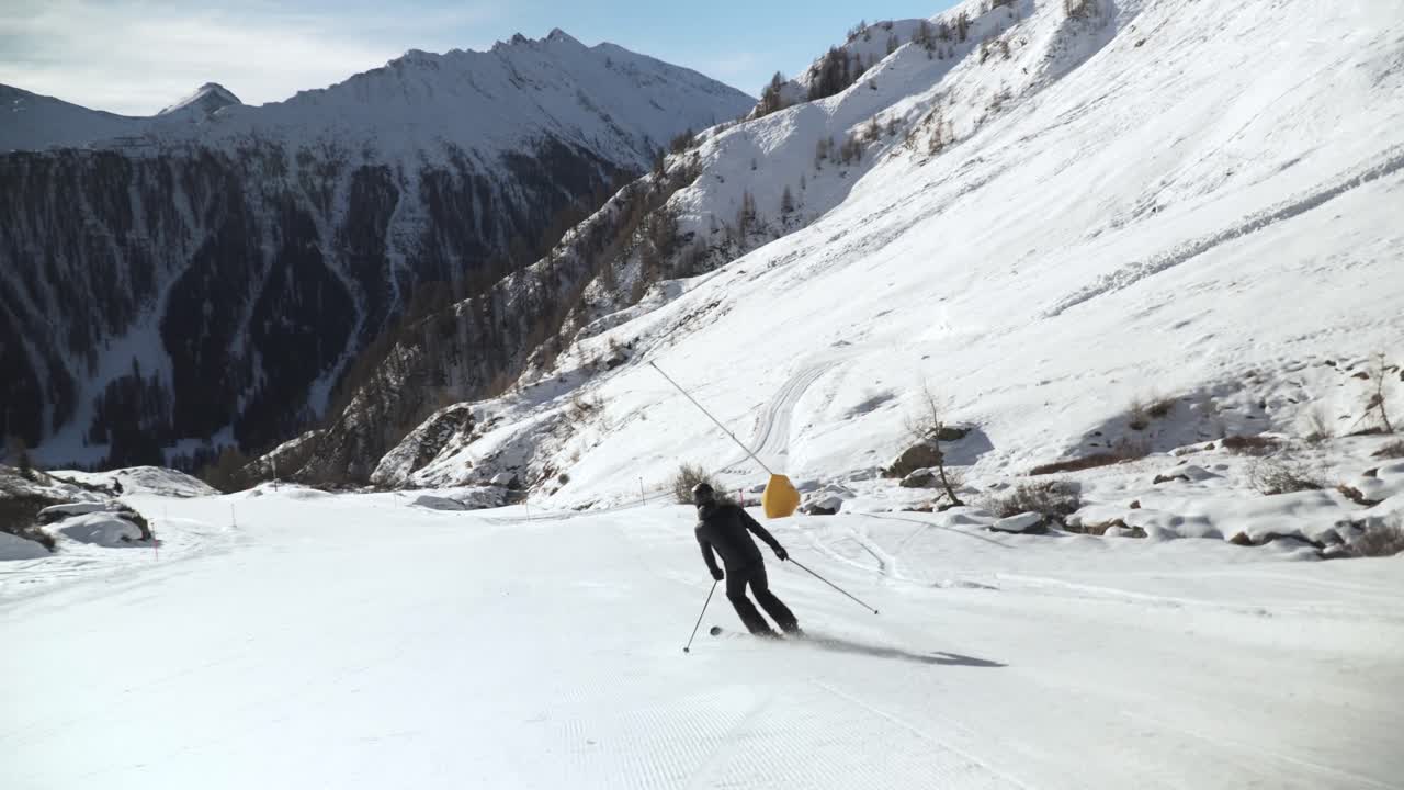 Sciatore che effettua curve lentamente su una pista bianca e immacolata nelle Alpi austriache.