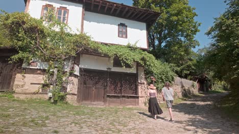 una joven pareja de turistas adolescentes disfruta explorando un romántico pueblo búlgaro.