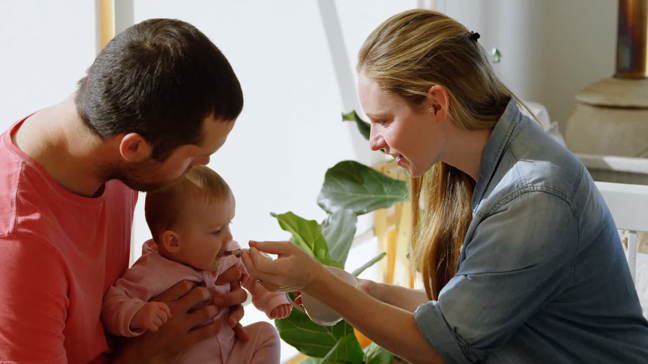 부모가 아기 소년에게 먹이를 주는 4k