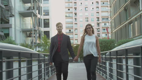 Happy-multiethnic-couple-holding-hands-and-walking-outdoor