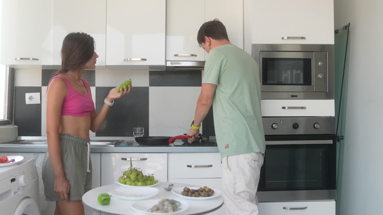 pareja cocinando y comiendo en una cocina