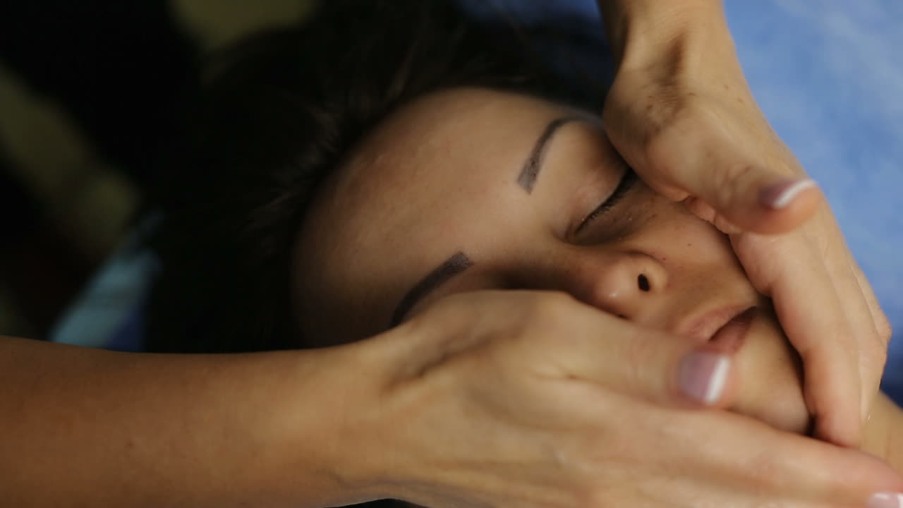 Woman having spa massage. Woman with closed eyes having massage her face