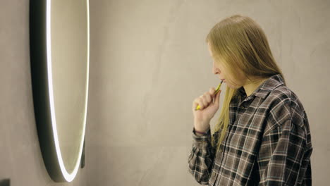 mujer cepillándose los dientes en un baño