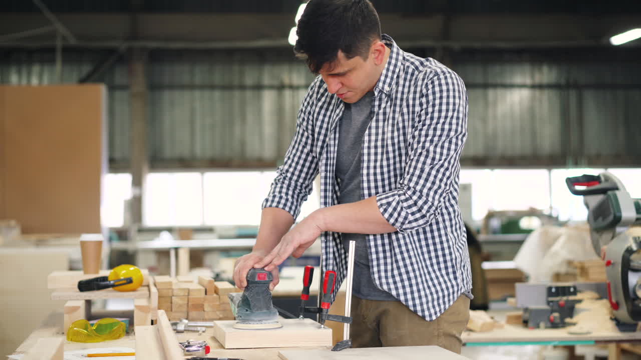 Man Sanding Wood in a Workshop