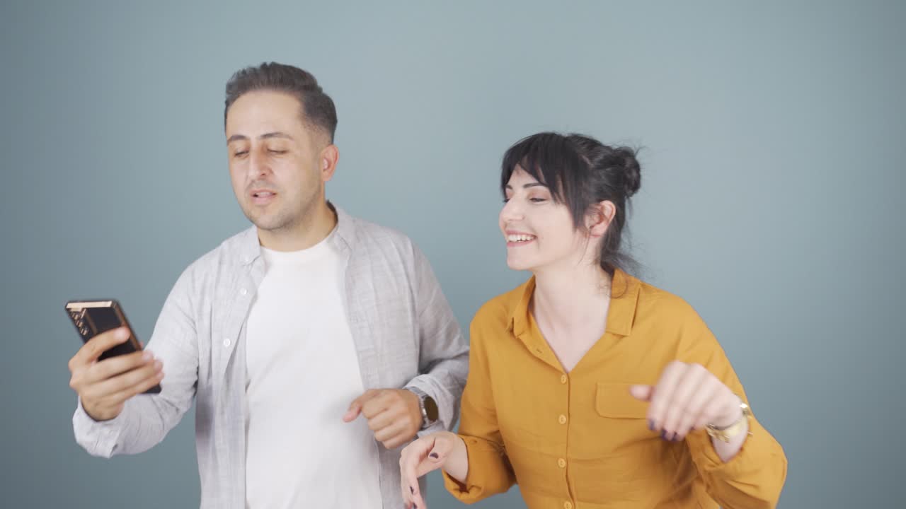 손에 드폰을 들고 춤추는 커플.