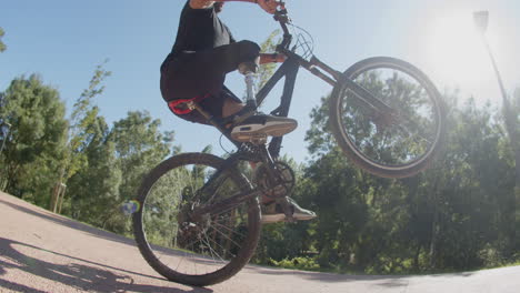 long shot of man with disability doing trick on bike outdoor