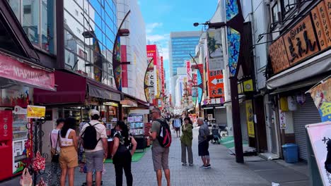 busy shopping street in tokyo with colorful signs and people walking along storefronts