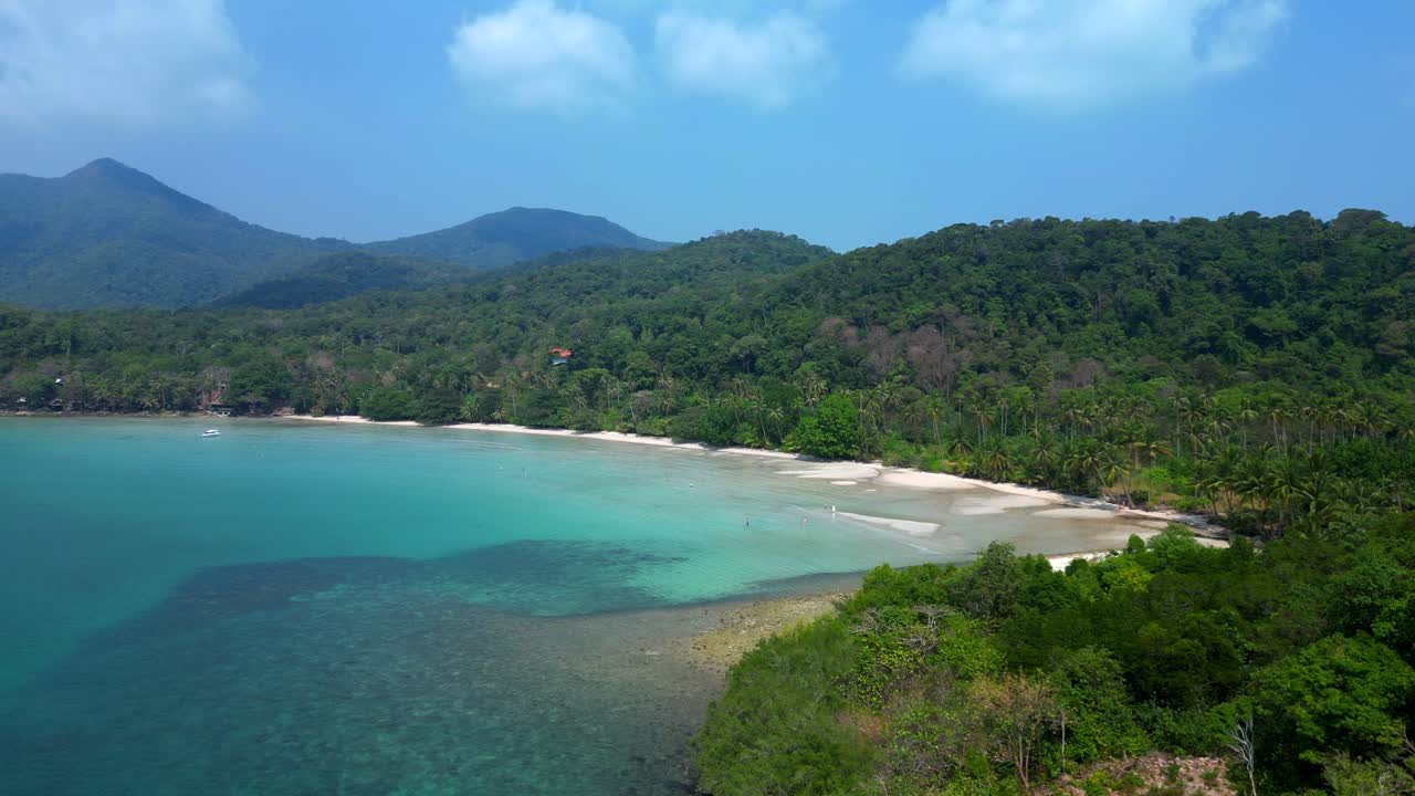 ong beach at koh chang island showing turquoise water and green rainforest in Trat Province, Thailand. Amazing aerial view flight static tripod hovering drone