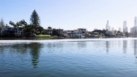 calm water reflecting houses and skyline