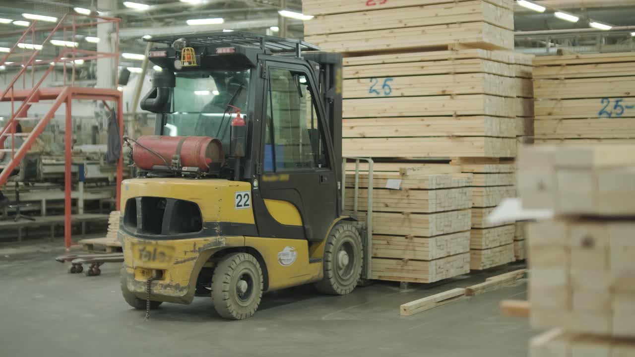 Gelber Gabelstapler mit Blinklichtern im Holzlager