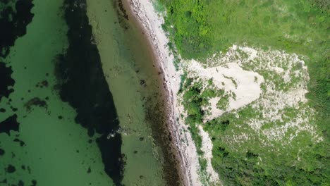 ven island, sweden: drone flying overhead over the rugged coastline of ven island and it's the turquoise waters