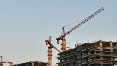 static shot of cranes working on building construction