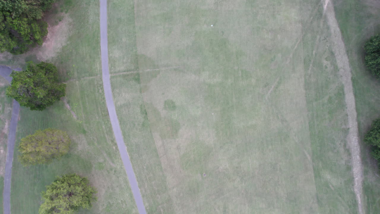 Aerial Drone, top down view of driving range, golf course, net, dusk
