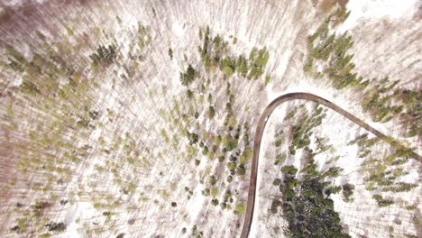 vista aérea de un bosque nevado con una carretera curva de asfalto