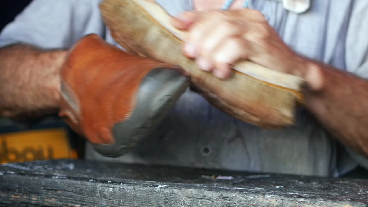 브러쉬로 갈색 가죽 부츠를 는 남자의 클로즈업.