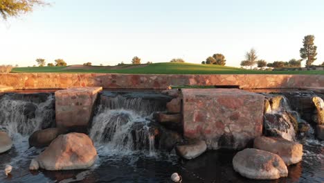 drone footage from a golf course near a residential neighborhood in arizona. low to high shot from a water hazard to overlooking the greens