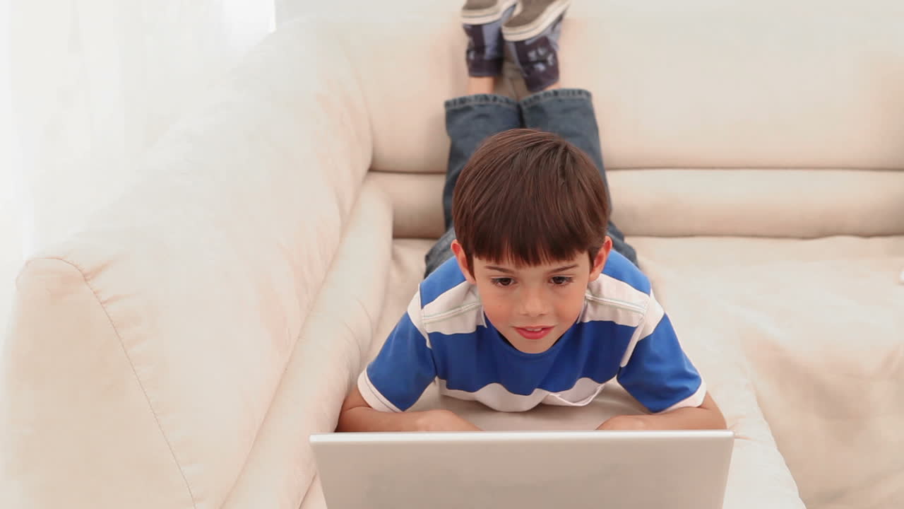 niño escribiendo en una computadora portátil