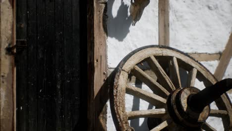 old wood wheel and black door at white house