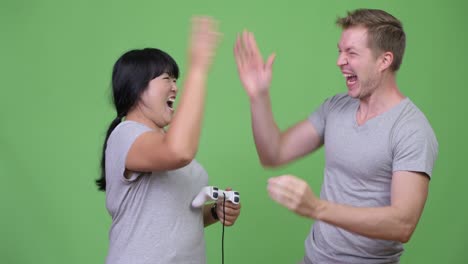 young multi-ethnic couple playing games and winning together