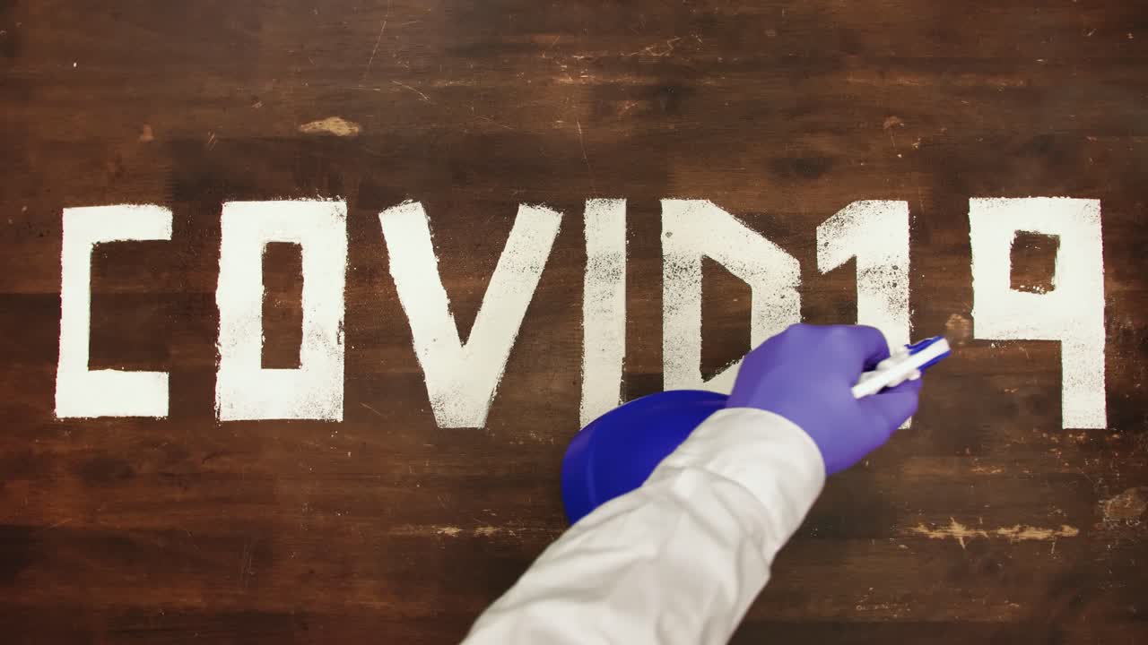 Cartello Covid-19 spruzzato con disinfettante per eliminare il virus