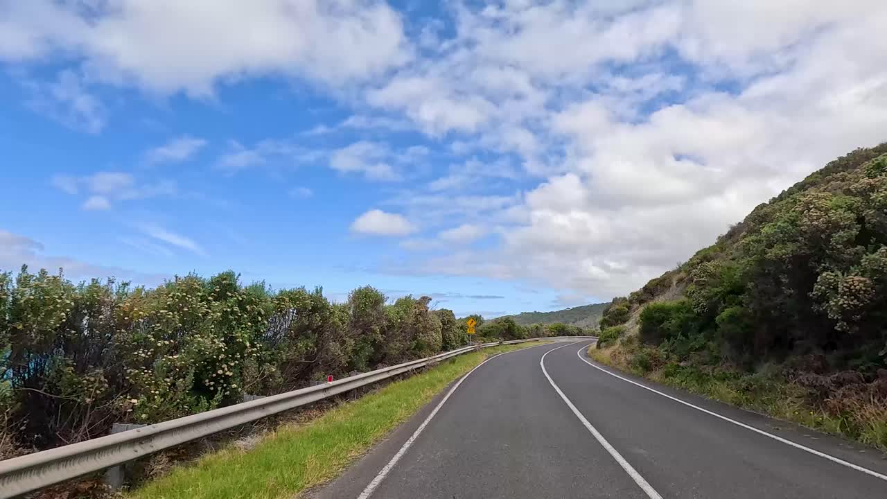 A 14-second video captures a drive along the Great Ocean Road, showcasing coastal views, lush greenery, and a clear blue sky