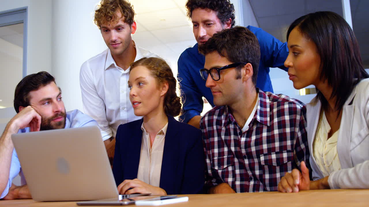 grupo de ejecutivos de negocios discutiendo sobre una computadora portátil