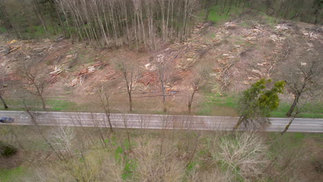 Aerial-View-Of-Car-Driving-In-The-Road-Along-The-Deforestation