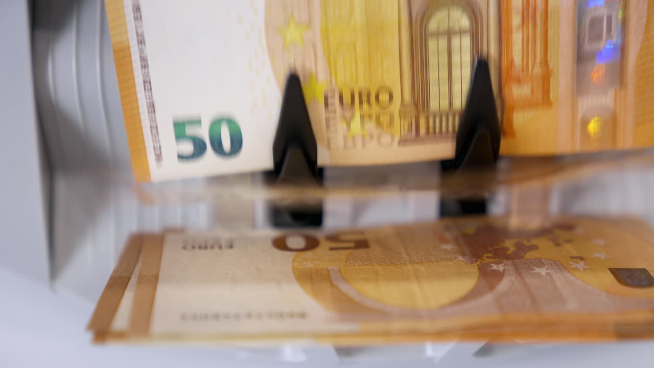 Euro currency on money counting machine. Electronic money counter machine is counting 50 euro banknotes. Automatic money counting machine.