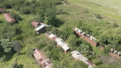 imágenes aéreas de drones de las dependencias de una granja abandonada en crecimiento de suciedad en descomposición