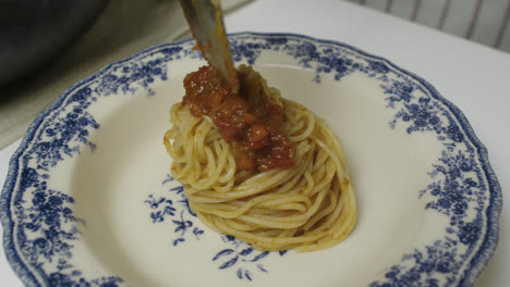 adding bolognese sauce on top of pasta