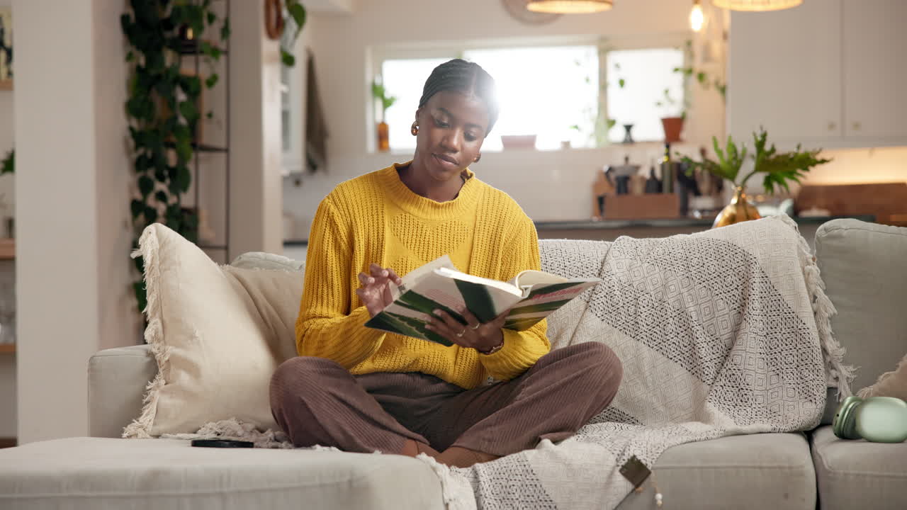 Frau liest ein Buch auf dem Sofa