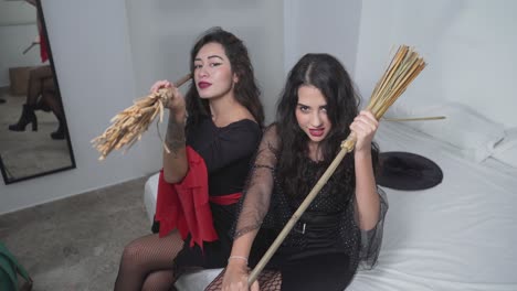 two girls in witches costumes on a bed