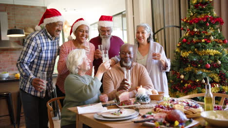 Retrato-De-Amigos-Mayores-Felices-Y-Diversos-Bebiendo-Un-Brindis-En-La-Mesa-De-La-Cena-De-Navidad,-Cámara-Lenta