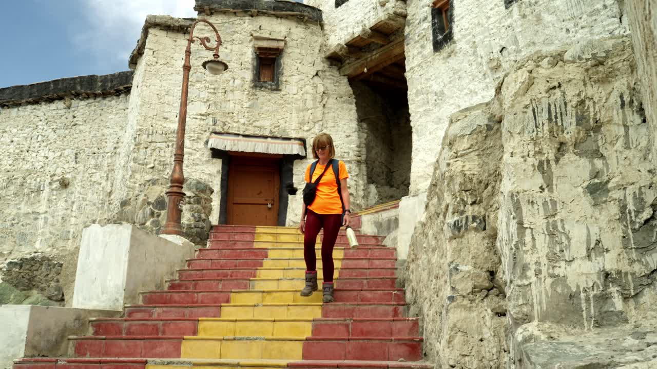 un viajero desciende las escaleras en thiksey gompa en leh, ladakh, un sereno templo budista en el himalaya.