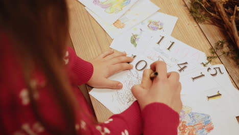 girl coloring pictures at table