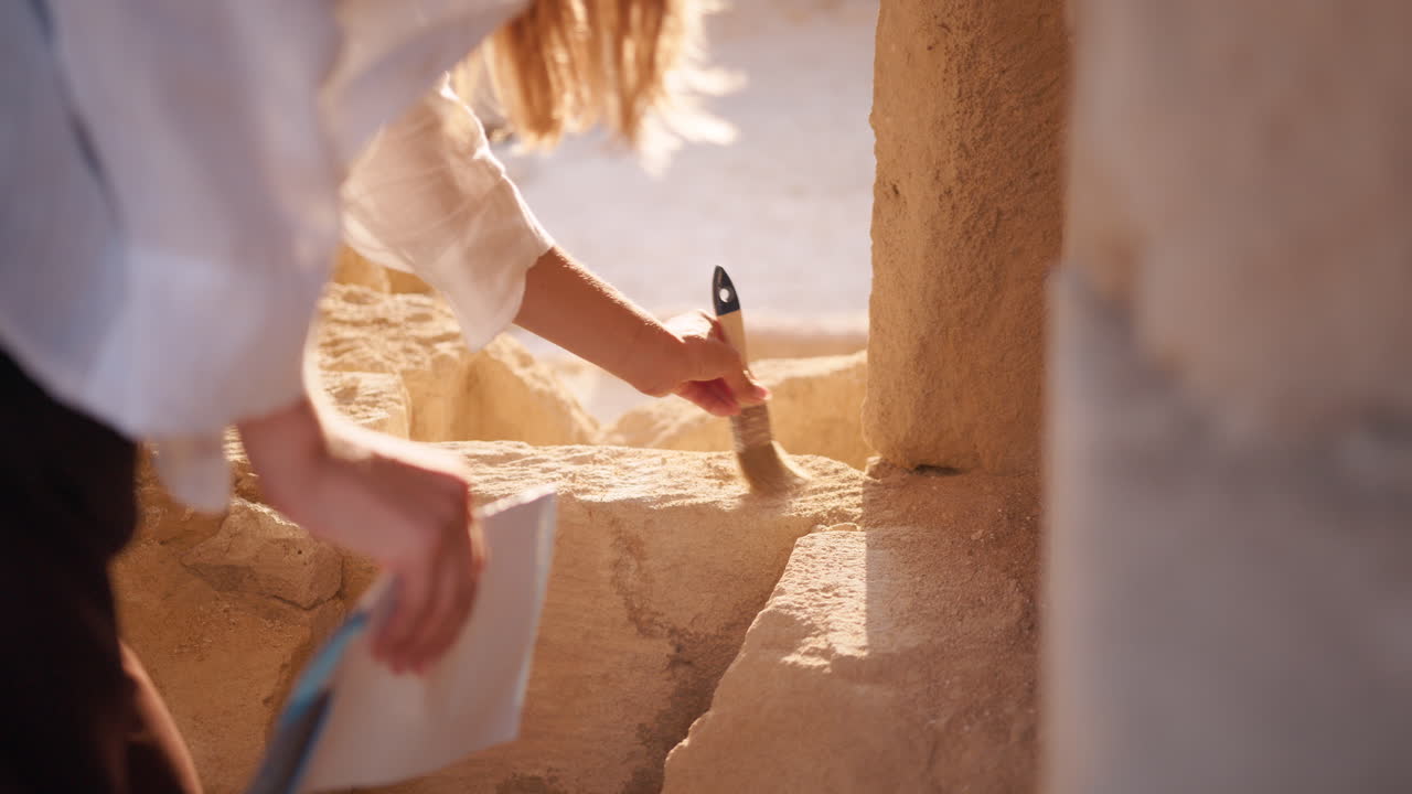arqueólogo limpiando el antiguo muro de piedra