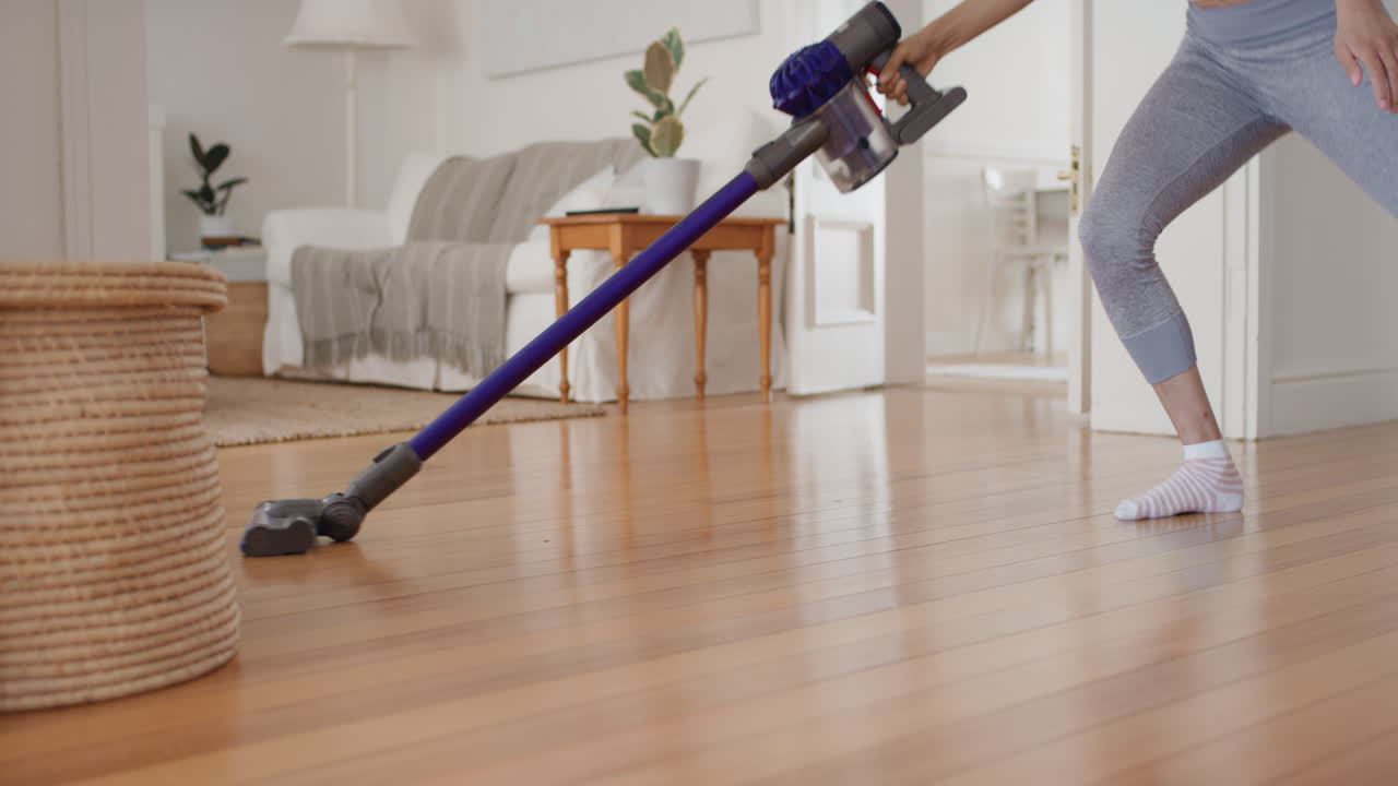 adolescente feliz bailando con la aspiradora haciendo tareas limpiando la casa divirtiéndose baile tonto escuchando música usando auriculares disfrutando de una mañana de fin de semana despreocupada en casa 4k