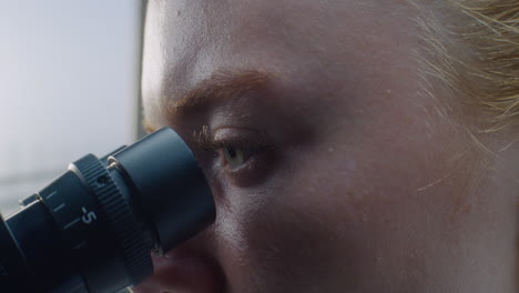 scientist looking through a microscope