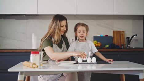 mother and young daughter in kitchen prepare food