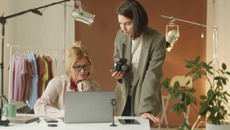 fotógrafa discutiendo imágenes en una computadora portátil con un modelo senior