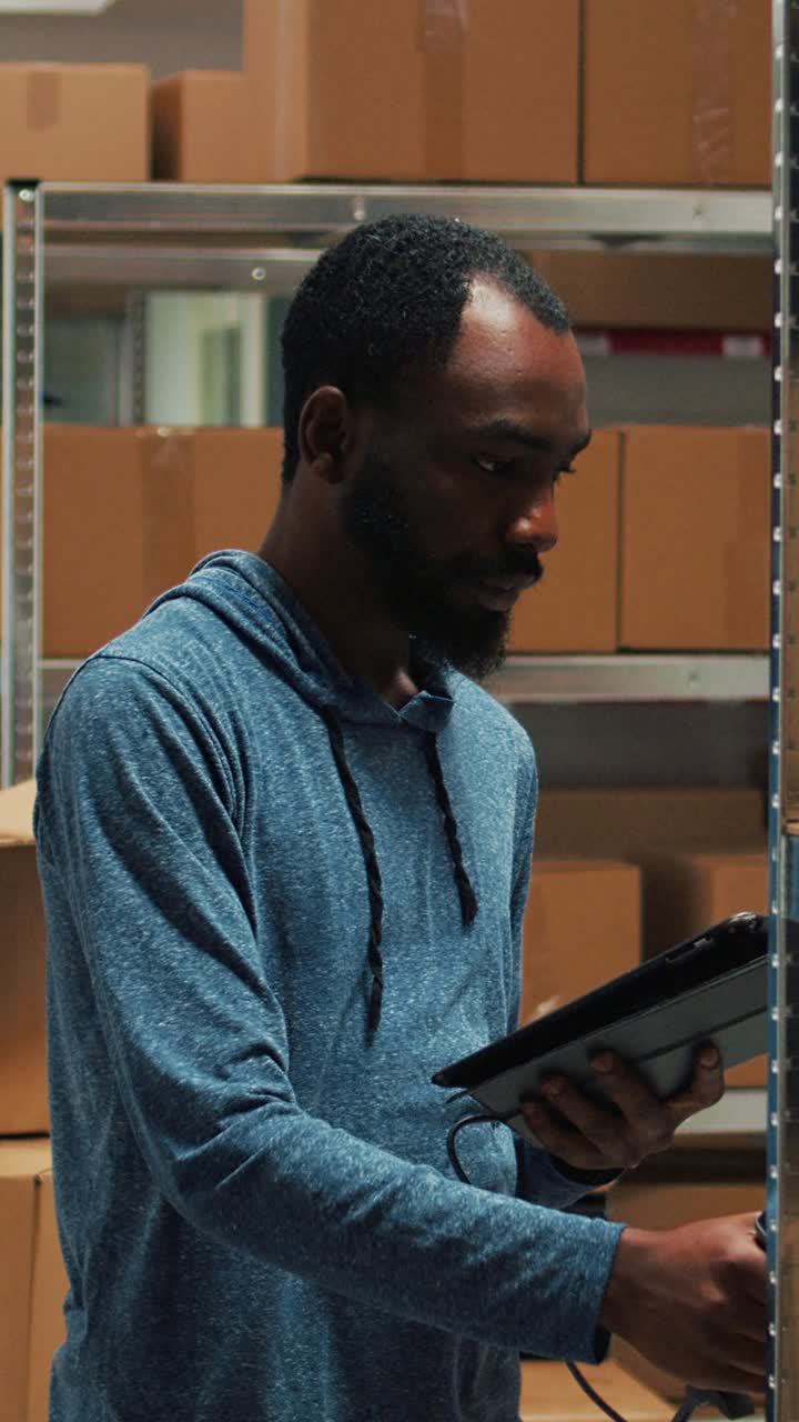 Vertical video: Male entrepreneur scanning storage room produucts with gadget and scanner