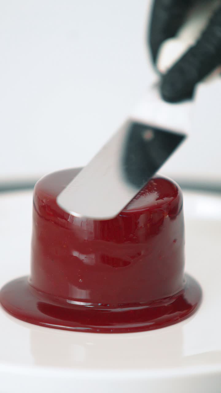 Pouring glossy chocolate glaze over a layered mousse and brownie dessert. Close-up food shot ideal for pastry, gourmet, and dessert visuals