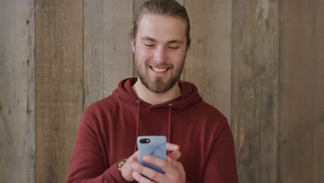 Retrato-De-Un-Joven-Usando-Un-Teléfono-Inteligente-Enviando-Mensajes-De-Texto-Navegando-En-Línea-Disfrutando-Enviando-Mensajes-Sms-Comunicación-Móvil-Sonriendo-Feliz-En-Cámara-Lenta