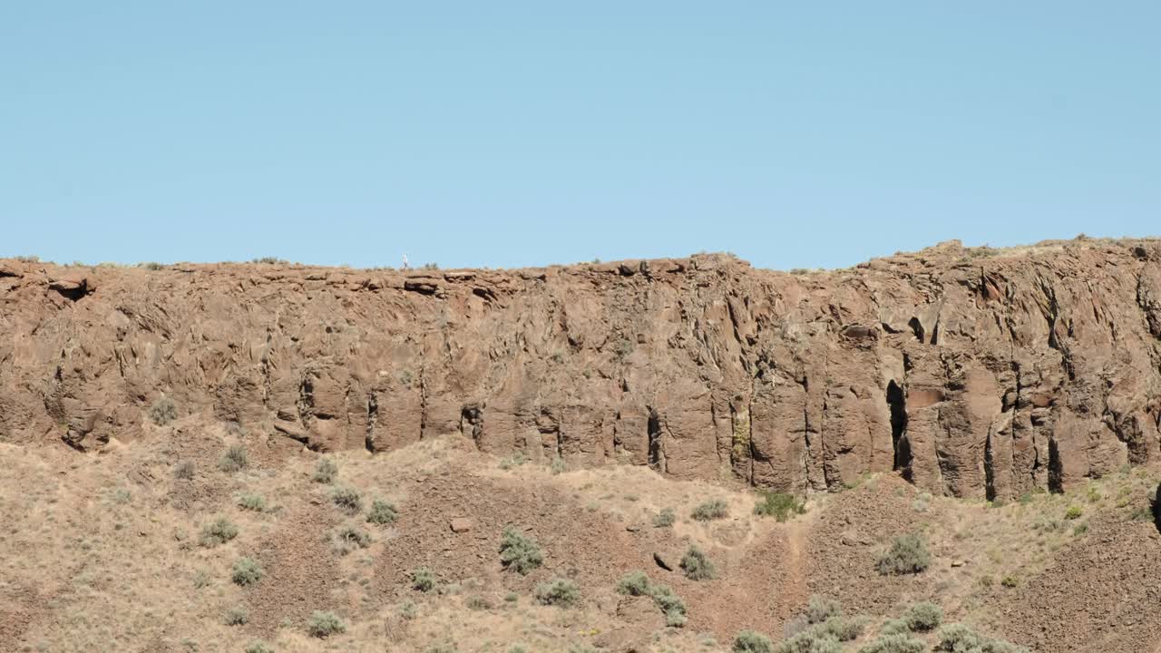 un excursionista solitario camina por el borde de un acantilado en frenchman coulee, en el estado de wa.
