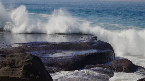 Ocean-wave-exploding-onto-rocks-and-washing-over