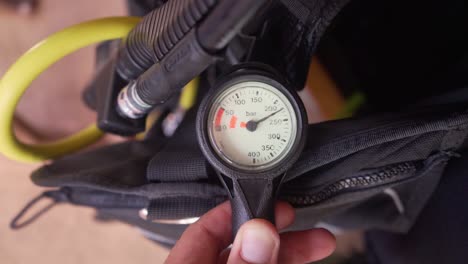 antes de una inmersión, alguien revisa su aire para asegurarse de que el tanque tenga suficiente aire