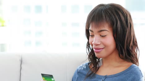 smiling woman holding mobile phone and credit card