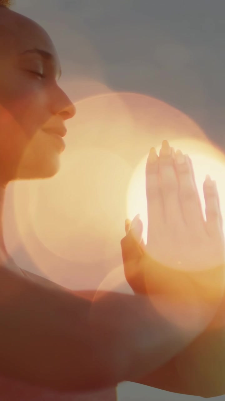 Video verticale: Donna che pratica yoga che abbassa le braccia in posizione di preghiera da braccia alzate per trovare calma mentre i bagliori del sole si spostano.